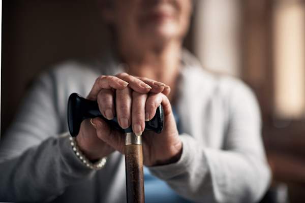 woman's hands holding cane