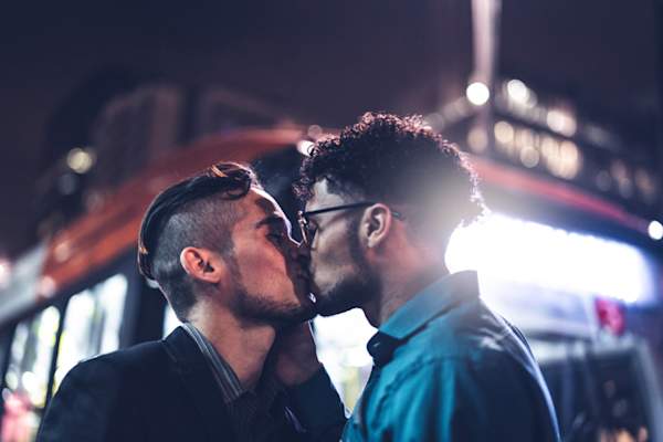 two men kissing on street