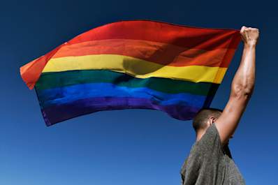 Man waving a gay pride flag.