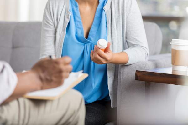 woman with doctor holding pill bottle
