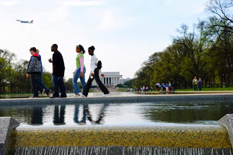 Young people walking with the Lincoln Memorial in the background