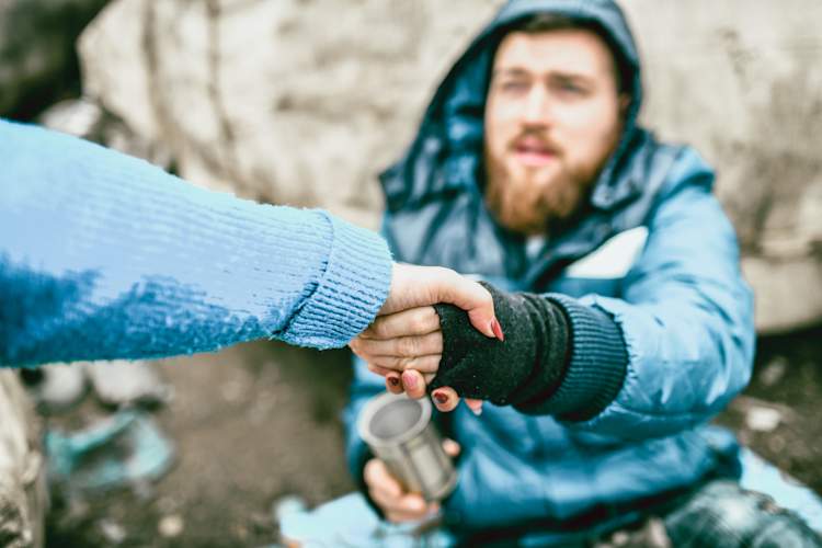 Homeless Man Shaking a Person's Hand
