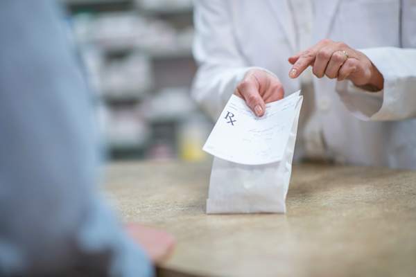 Pharmacist giving customer a prescription medication