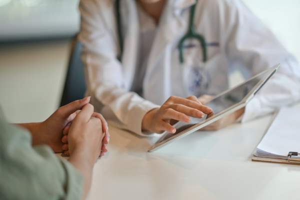 woman talking to doctor, close up on hands
