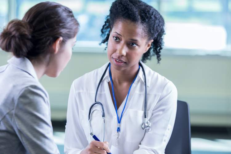 doctor talking to unrecognizable patient