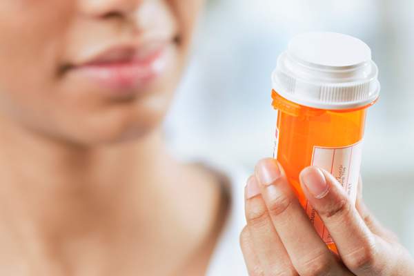 woman looking at pill bottle