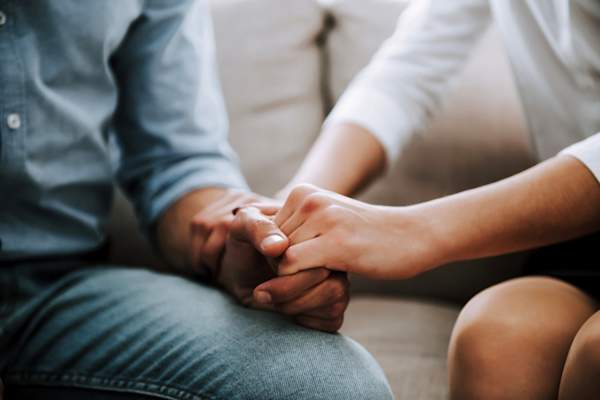 close-up of man and woman holding hands