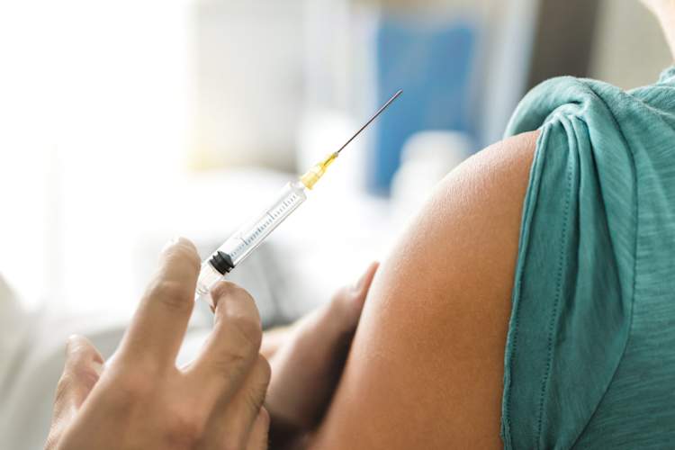 Physician or nurse giving injection in patient's arm