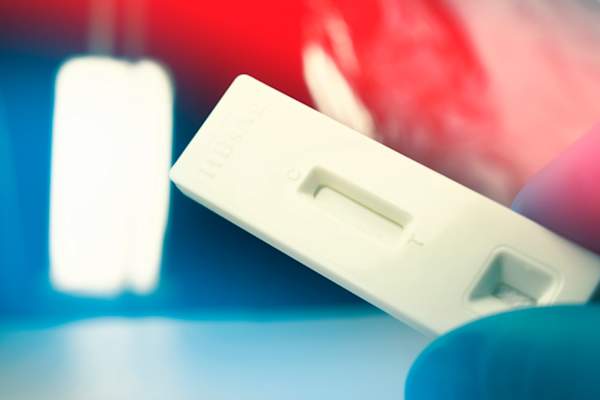 gloved hand holding rapid test