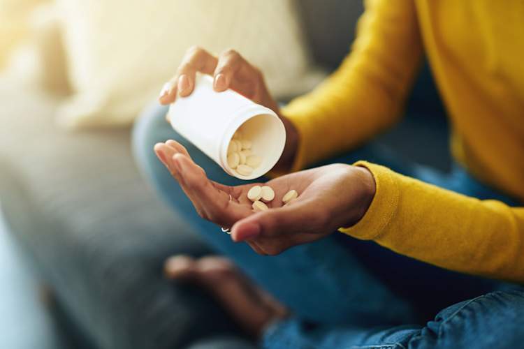Woman's hands taking pills