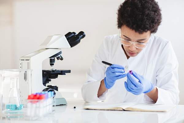 Scientist in research lab writing on blood sample