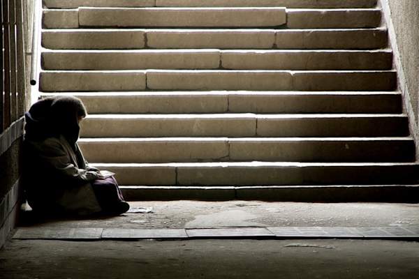 Homeless woman at bottom of stairs