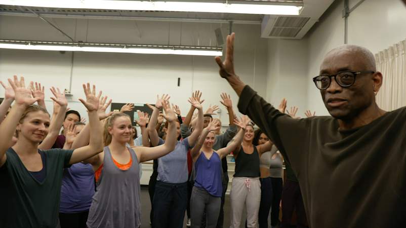 4 BillTJonesinrehearsalwithstudentswitharmsraised