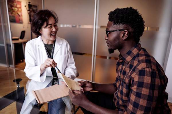 Young African-American man talking to female doctor