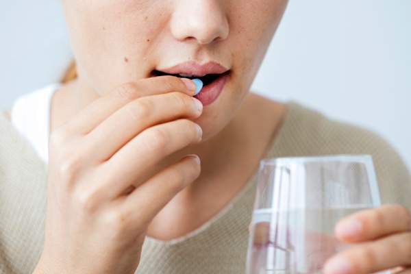 Young woman taking a pill
