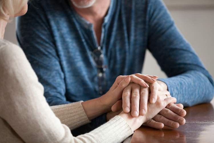 Close up of two seniors holding hands