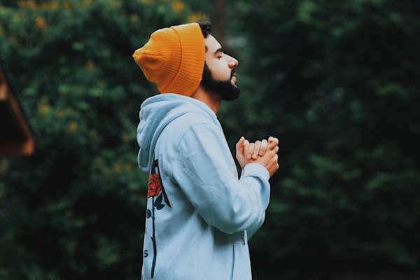 calm man with eyes closed and hands clasped