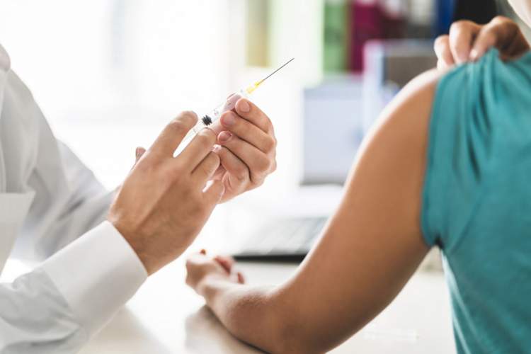 doctor giving young person vaccine