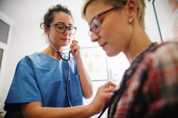 doctor using stethoscope to examine patient