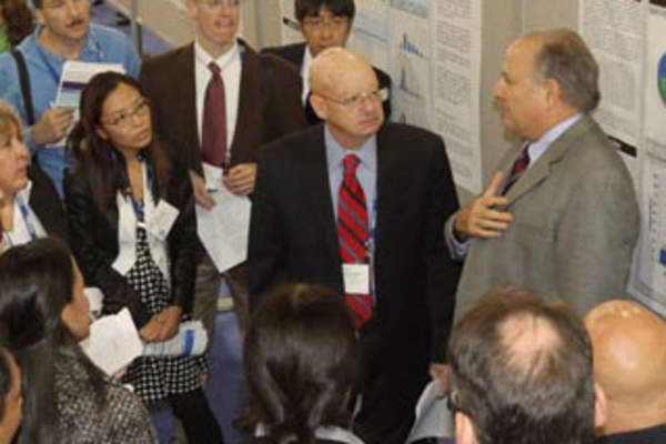 Attendees discuss a poster presentation at IDWeek 2017 (Credit: Infectious Diseases Society of America)