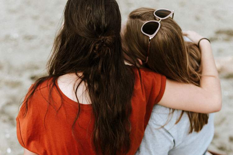 woman with arm around other woman