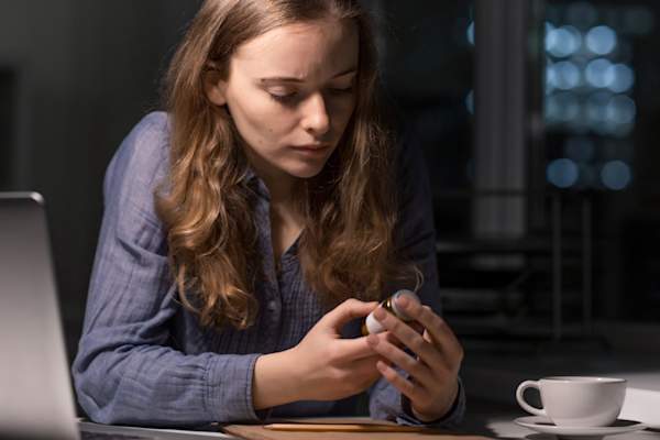 woman looking at pill bottle