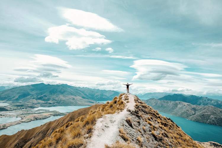 person standing at top of mountain in New Zealand
