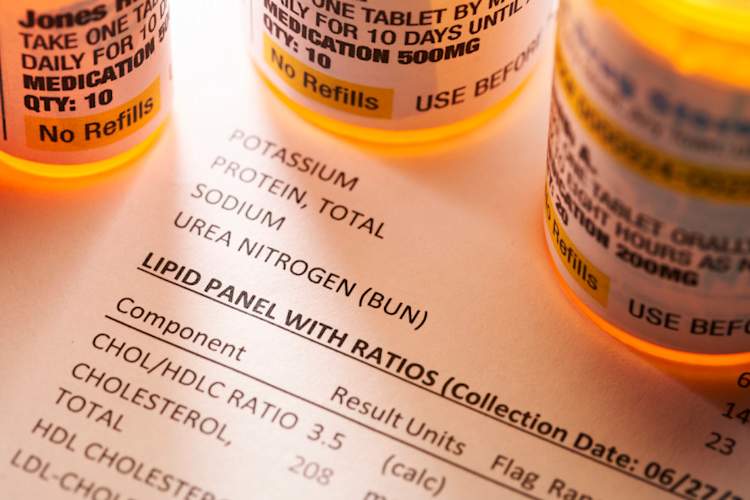Prescription medicine bottles on lipid blood test report