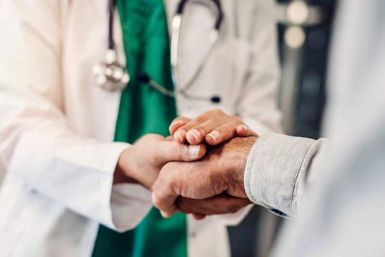 Health worker holding patient's hand