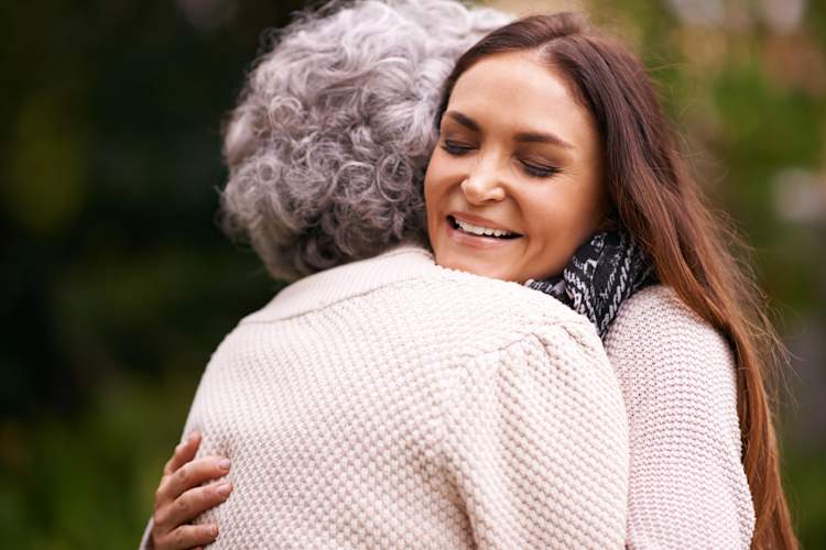 Woman hugging senior mother.