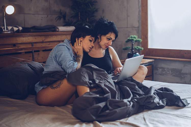 couple in bed looking at porn
