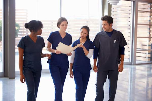 nurses walking together and looking at medical chart