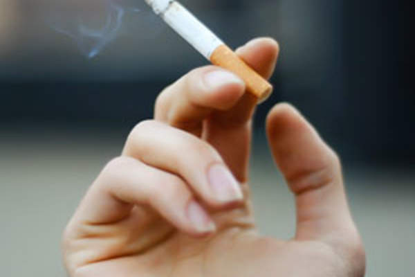 Hand holding lit cigarette