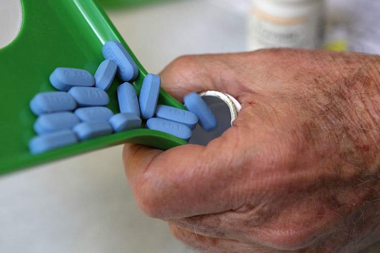 A pharmacist pours Truvada pills into the bottle
