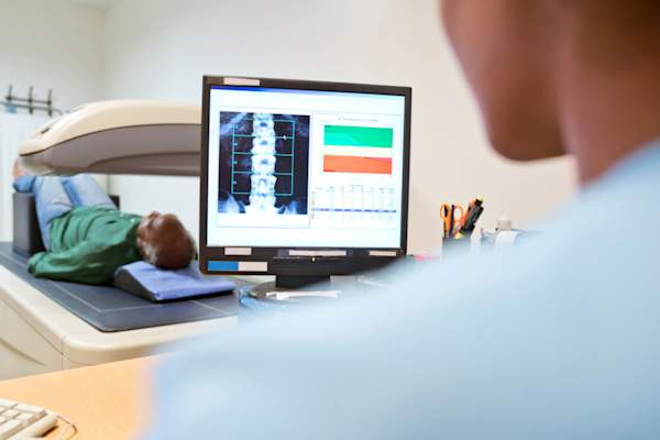 nurse giving senior man bone density test on spine
