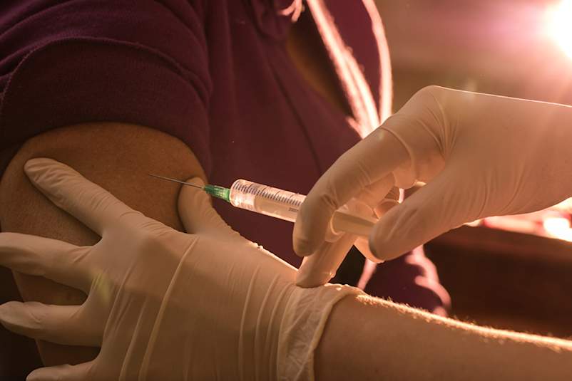 Medical professional administering a vaccine.