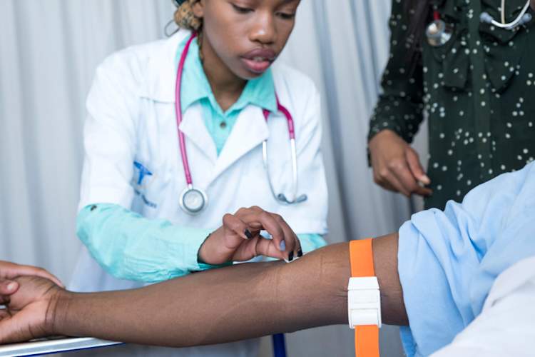 doctor drawing blood from patient