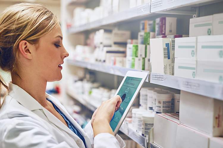 Doctor in hospital pharmacy looking at electronic chart