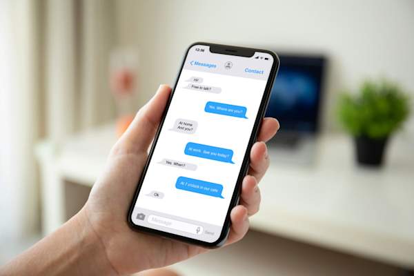 Woman hand holding phone with app messenger on the screen