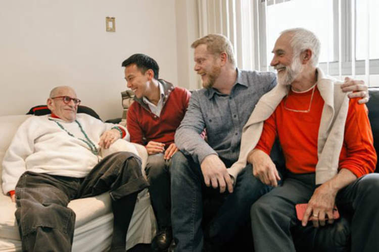 Larry Kramer, Kelsey Louie of GMHC, Mark S. King, and Larry's husband, David Webster
