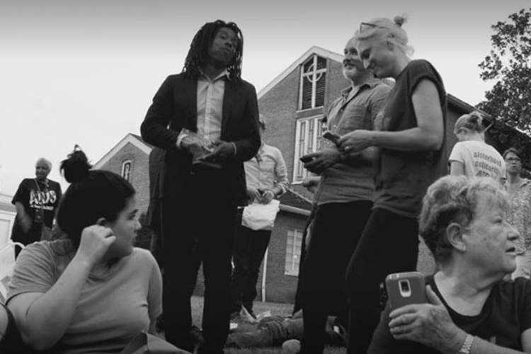 (Left to right) Jaron Benjamin, Paul Davis and Jennifer Flynn stand with protesters after mass arrests in Washington, D.C. on July 10, 2017