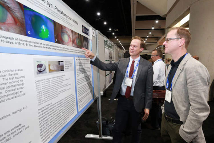 Attendees discuss a poster presentation at IDWeek 2017 (Credit: Infectious Diseases Society of America)