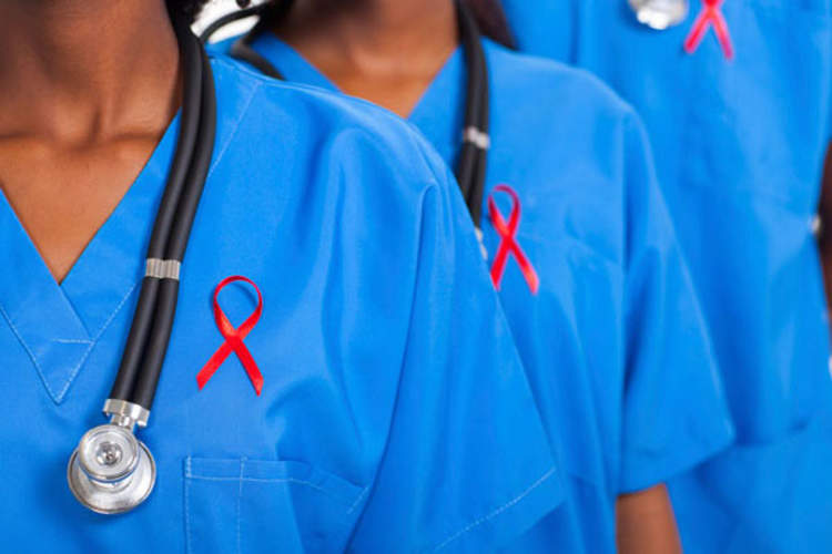 three people in scrubs with red ribbons