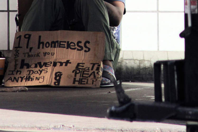Homeless teenager with sign asking for help