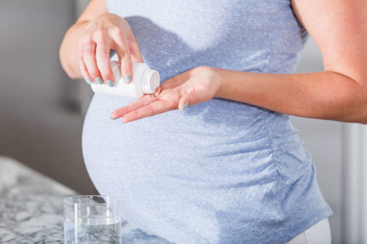 Pregnant woman with pill bottle
