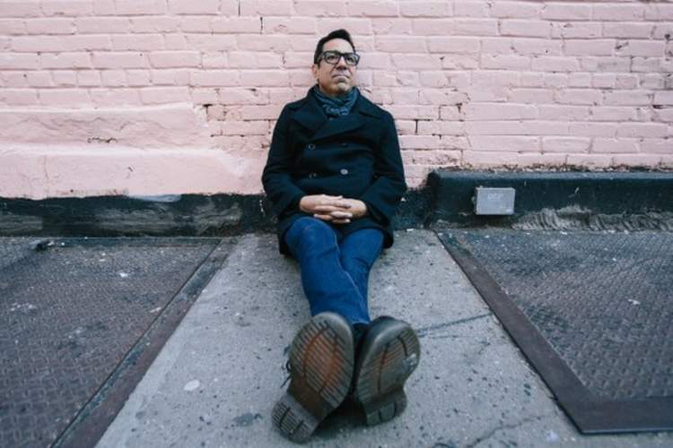 Charles Sanchez sits on a sidewalk in New York City