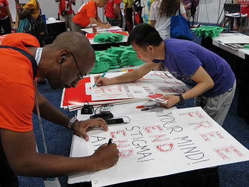 Harlan Smith, of Atlanta, Ga., and Tony Zheng, of China, make signs before the mobilization begins.