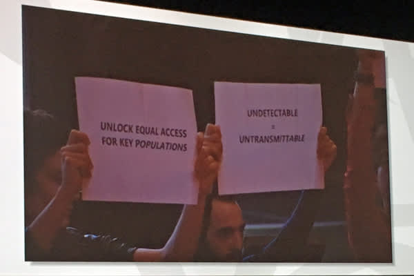 Activists at the IAS 2017 opening session hold up signs saying, 'Unlock equal access for key populations' and 'Undetectable = Untransmittable' (Credit: Warren Tong)