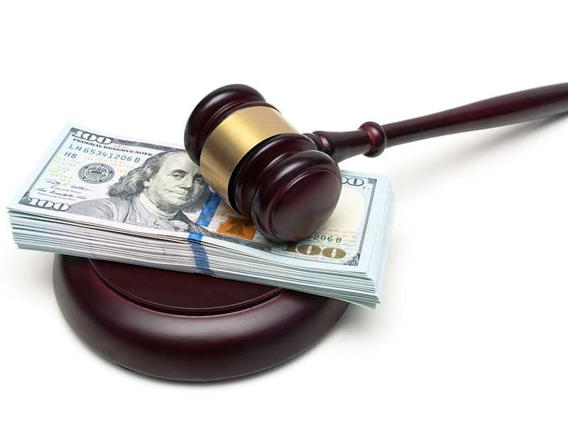 This is a photo of a gavel and and 100 dollar bills.