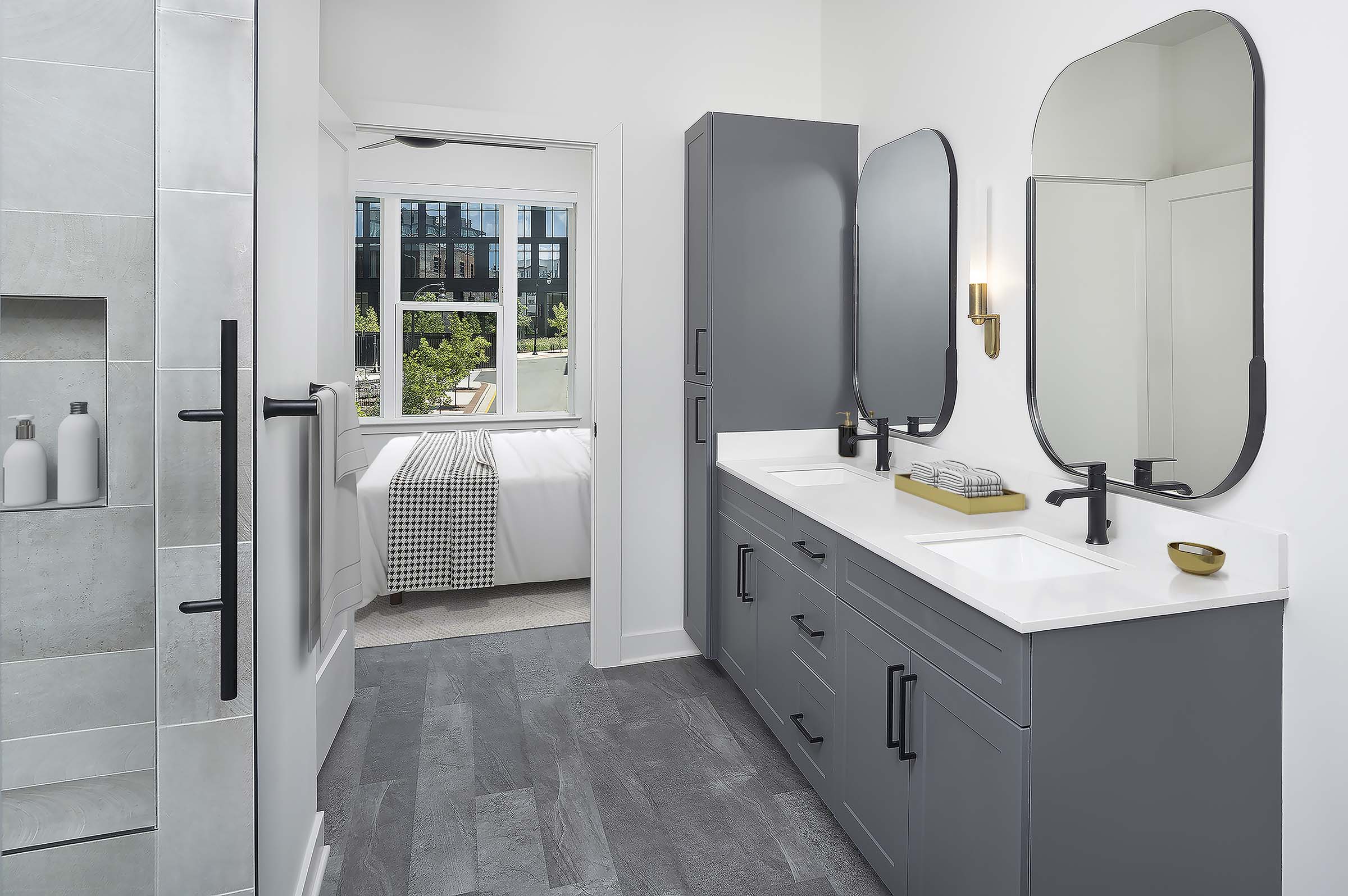 Ensuite bathroom with double vanity, walk-in shower, and wood-style flooring at Camden Durham apartments in Durham, NC.